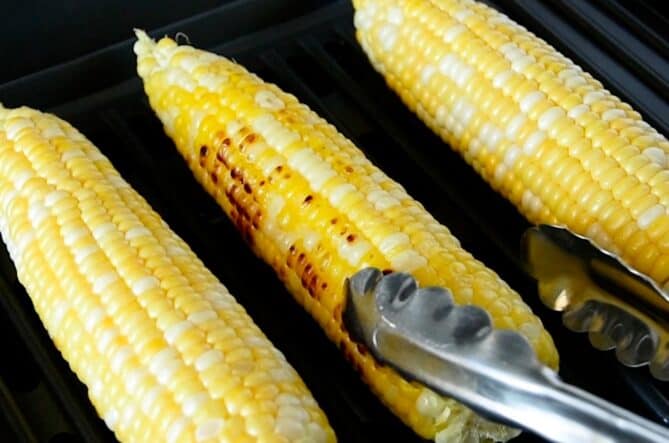 Cobs of corn cooking on a grill
