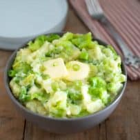 A large bowl of mashed potato mixed with green cabbage, spring onion, Irish cheddar and Irish butter