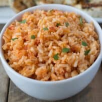 A closeup showing grains of rice colored with red tomatoes