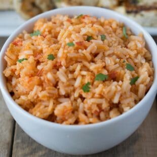 A closeup showing grains of rice colored with red tomatoes