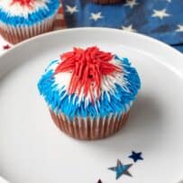 A closeup of a cupcake topped with red, white and blue frosting