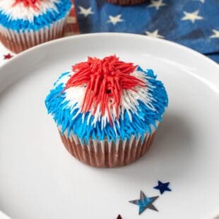 A closeup of a cupcake topped with red, white and blue frosting