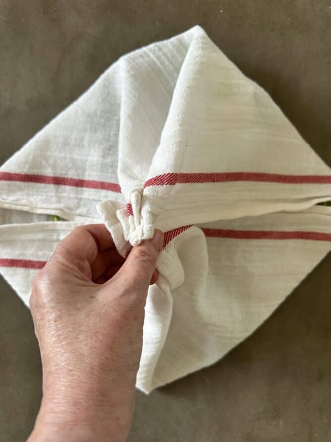 Folding a towel and holding it by the corners
