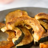 A closeup of sliced acorn squash showing the Indian spices