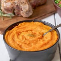 Vegan roasted carrots and parsnip pureed and served in a black bowl