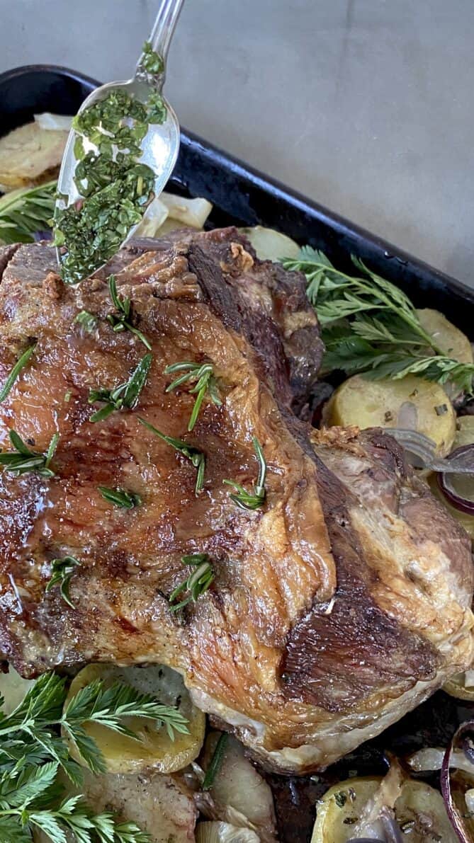 Drizzling mint sauce over roast lamb
