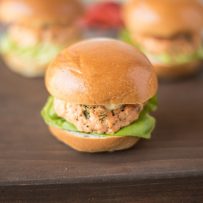 A salmon slider served on a brioche bun with lettuce