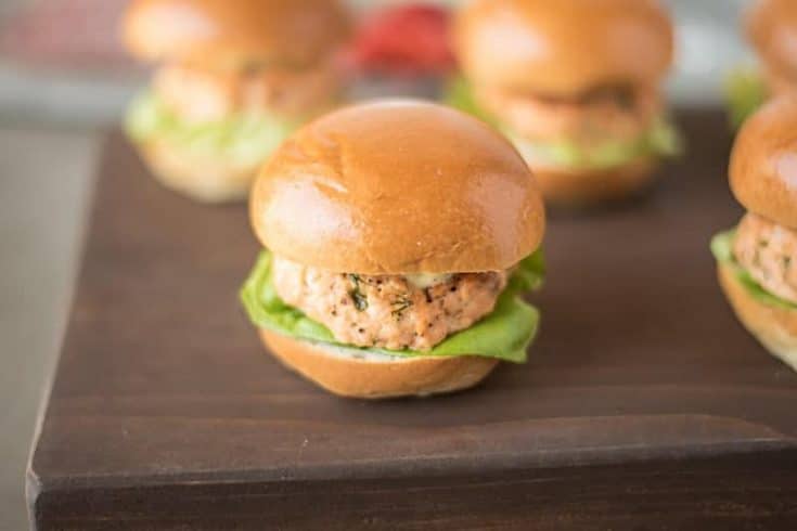 A salmon slider served on a brioche bun with lettuce