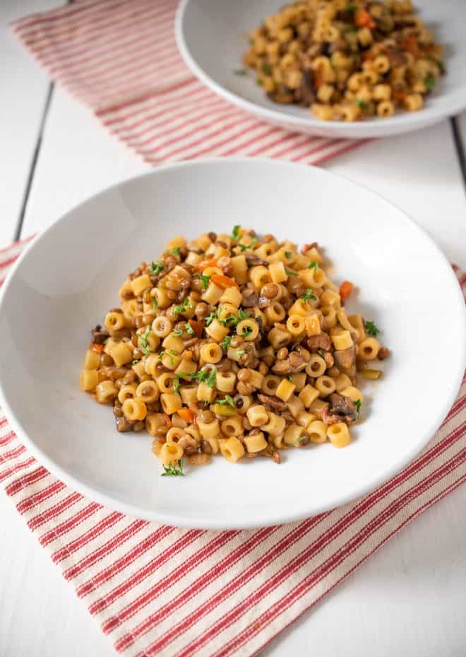 Ditalini pasta mixed with lentil sauce served garnished with chopped parsley