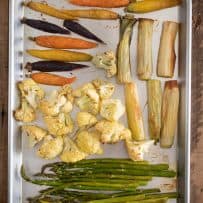 Asparagus, cauliflower, leeks and colorful carrots on a sheet pan freshly roasted