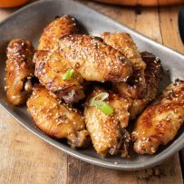 Crispy orange chicken wings in a pewter bowl
