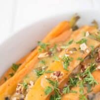 Chopped pecans and herbs on top of sliced carrots
