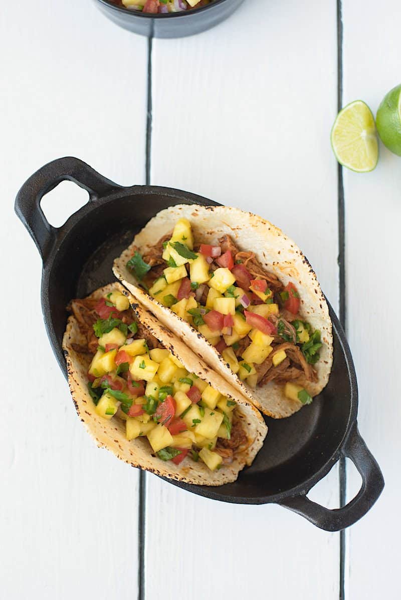 Slow cooker pineapple pepper carnitas tacos are big in name and big in flavor. Pork shoulder is slow cooked in a guajillo pepper, pineapple sauce, shredded and served in tacos with fresh pineapple salsa.
