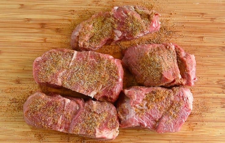 Chuck beef on a board rubbed with spices