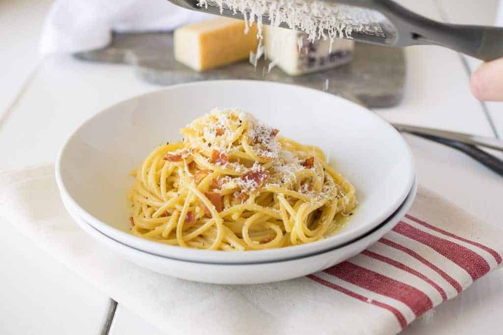 Cheese being grated over the pasta dish