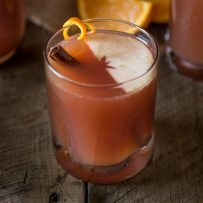 A glass of sparkling apple punch with a floating slice of apple