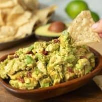 Scooping up guacamole with a tortilla chip