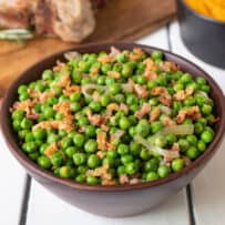 Crispy bits of pancetta and shallot in a bowl of green peas