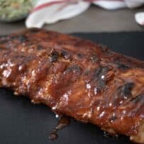 A rack of baby back ribs dripping with sauce