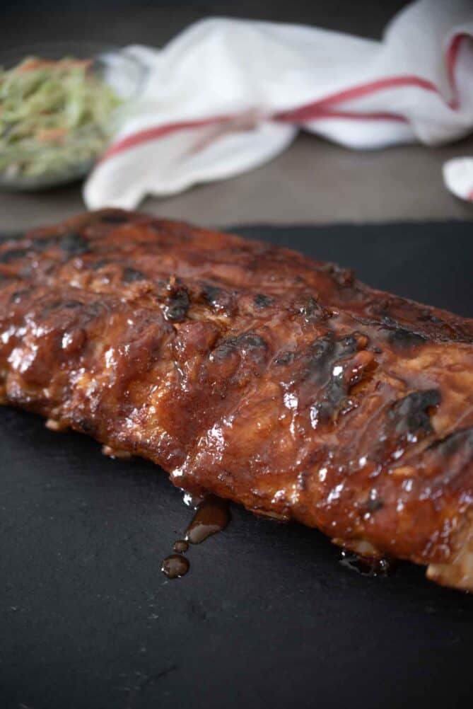 A rack of baby back ribs dripping with sauce