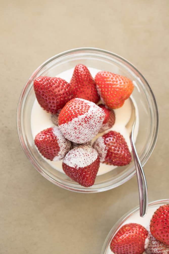 Strawberries viewed from overhead bathed in thick cream