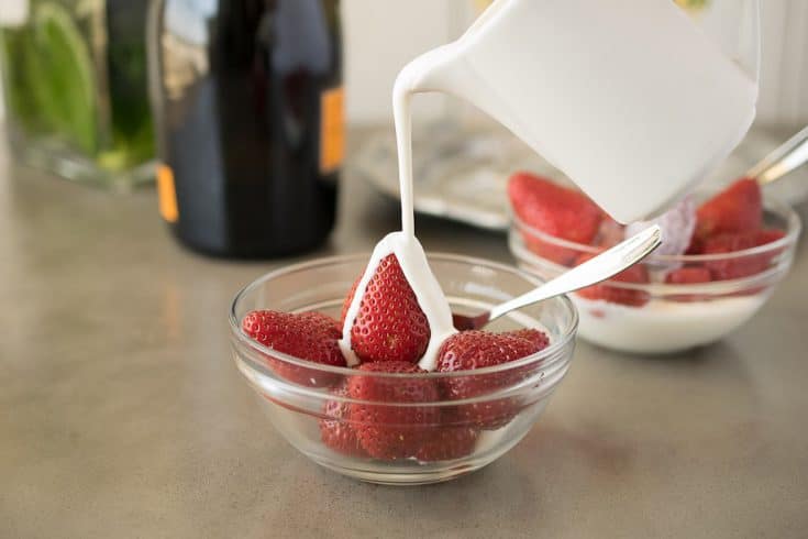A perfect pour of cream over strawberries