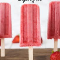 A display of frozen popsicles standing up with fresh strawberries