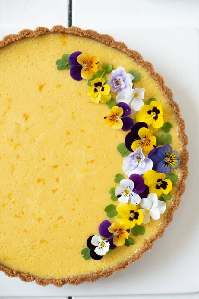 Pretty edible flowers garnish one side of the pie
