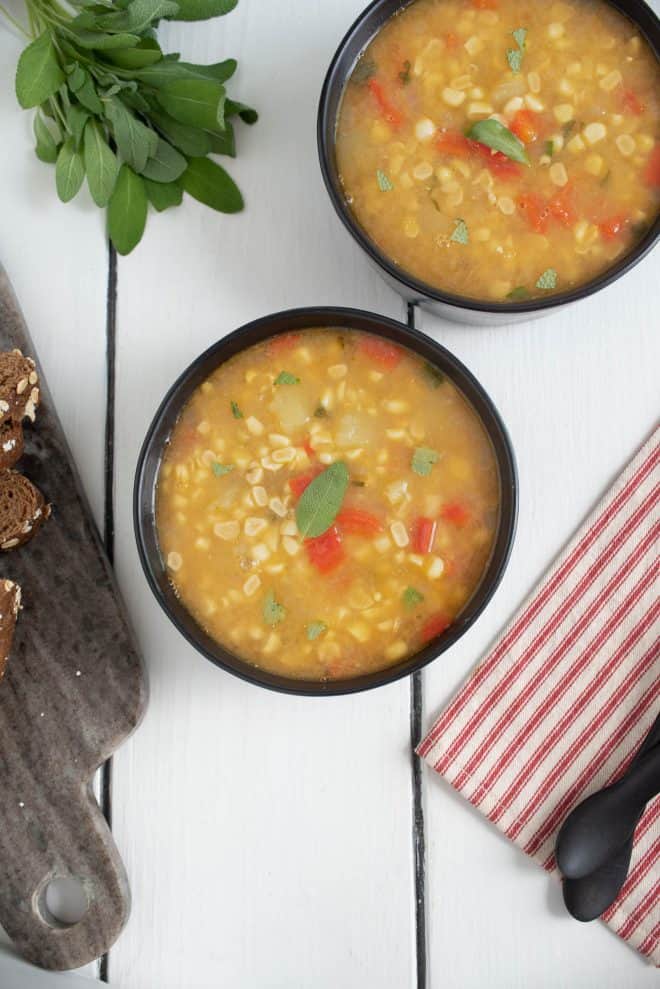 Viewed from overhead, 2 bowls of sweet corn sage soup