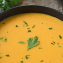 Green flecks of chopped parsley sit on top butternut squash soup