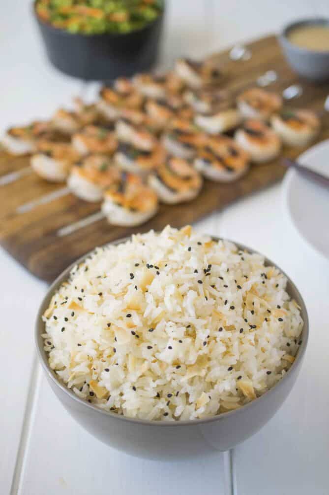 A grey bowl filled with rice garnished with black sesame seeds