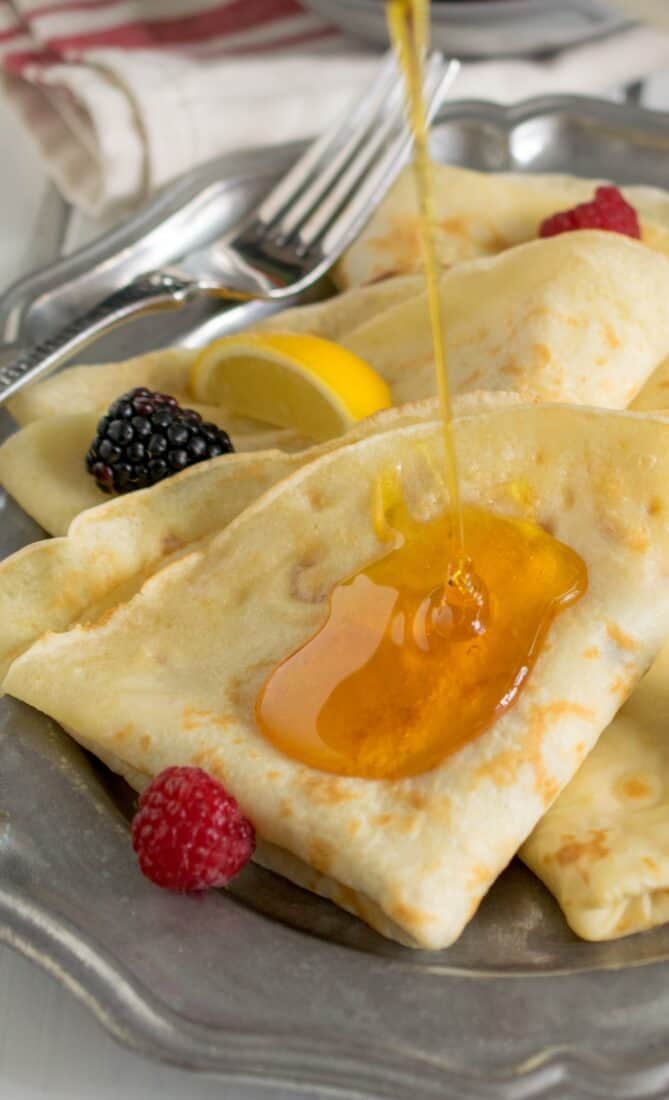 Drizzling syrup over crepe style pancakes
