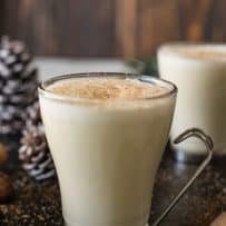Eggnog in a glass mug with a foamy topping and grated nutmeg