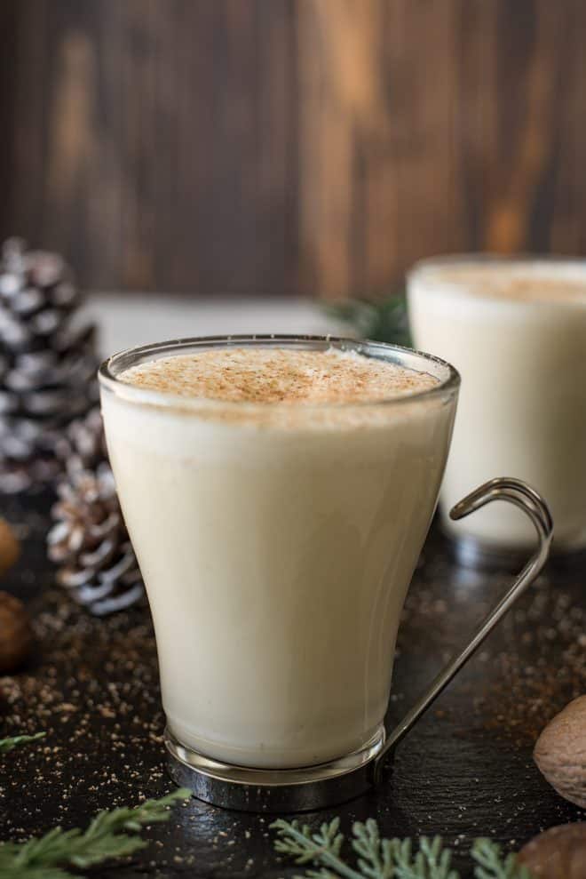 Eggnog in a glass mug with a foamy topping and grated nutmeg
