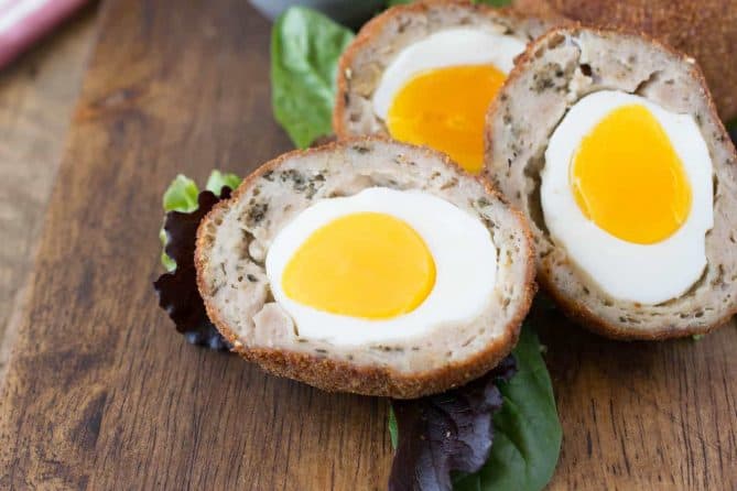A closeup of the inside of a Scotch egg showing the bright yolk