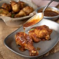 Pouring Spicy Chili Sauce over Turmeric Spiced Fried Chicken