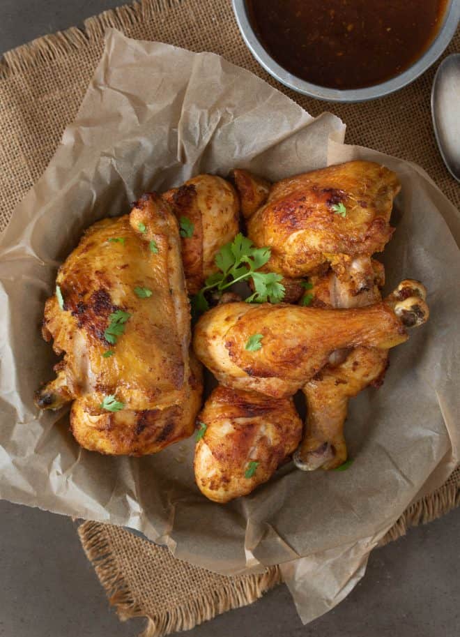 Drumsticks and thighs of Turmeric Spiced Fried Chicken garnished with cilantro