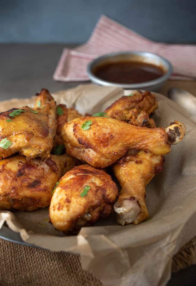 A bowl of Turmeric Spiced Fried Chicken pieces with a bowl of Spicy Chili Sauce