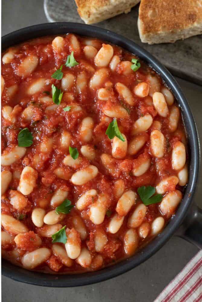 A closeup of Tuscan beans in a sage tomato sauce