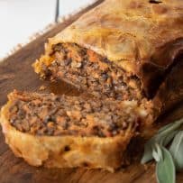 Mushroom Wellington on a serving board with a slice