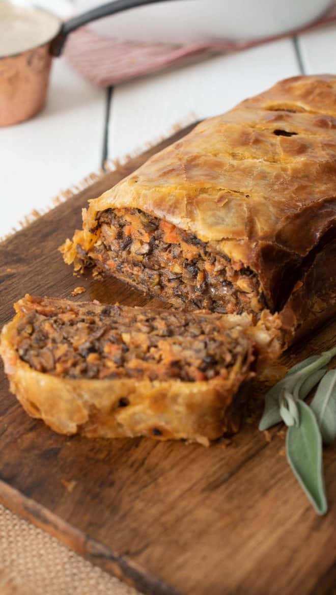 Mushroom Wellington on a serving board with a slice