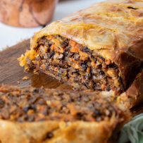 A sliced mushroom wellington showing the filling with mushroom and carrots