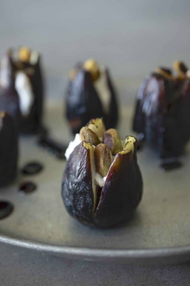 Roasted pistachios inside a fresh fig with goat cheese