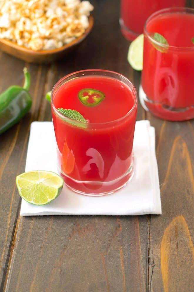 2 glasses watermelon jalapeño agua fresca garnished with jalapeño slices and fresh mint and a wedge of lime