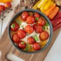 Confit tomatoes on top of whipped ricotta and goat cheese in a bowl