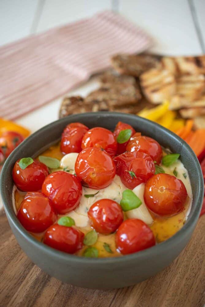 A bowl of ricotta and goat cheeses topped with tomatoes