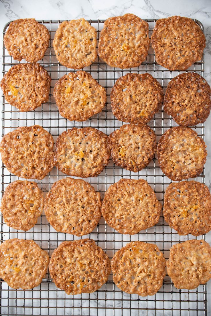 Florentine cookies cooling on a rack before filling with chocolate
