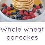 A stack of pancakes and served on a plate with fruit