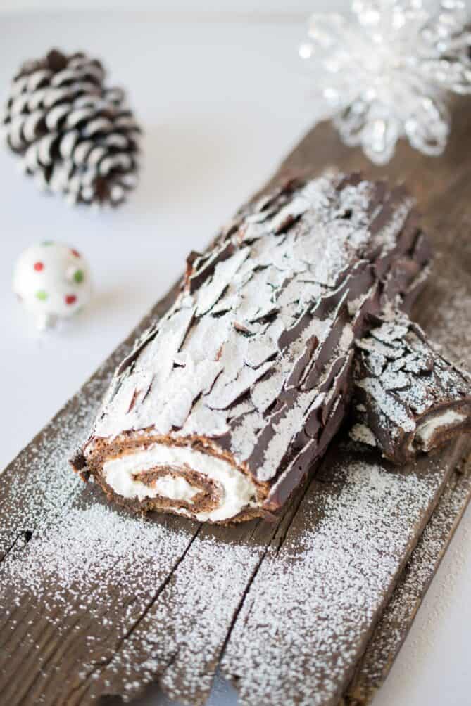 A chocolate cake roll yule log on a plank of wood