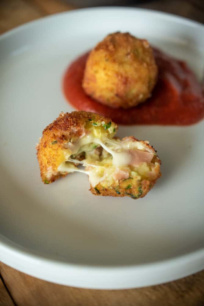 An Italian croquette cut open showing the meat and cheese inside.